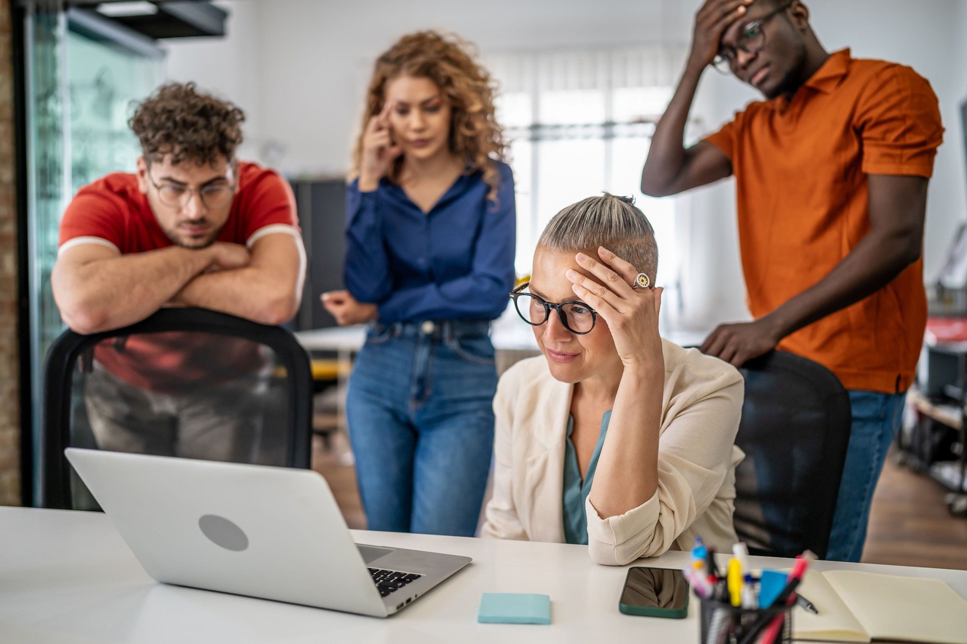 Stressed business team looking at problem on laptop